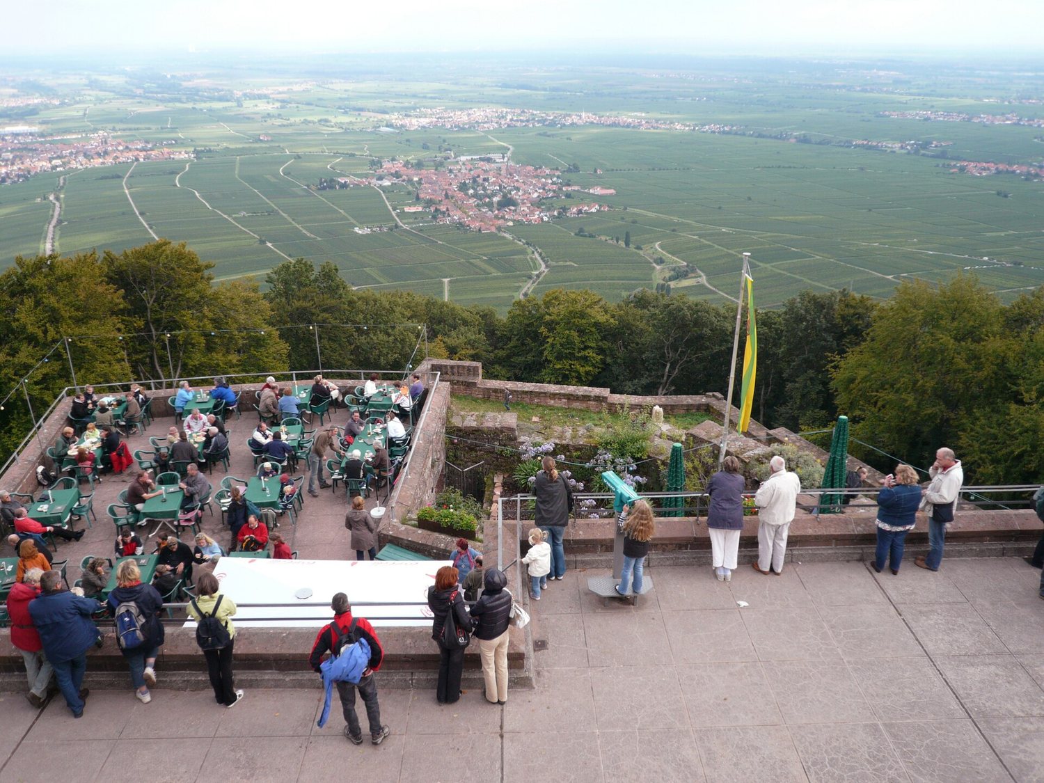 Die Terrasse in der Kernburg, darunter Rhodt und die Rheinebene. Der Blick, für den die Burg einmal gebaut wurde – heute mit Kaffee.