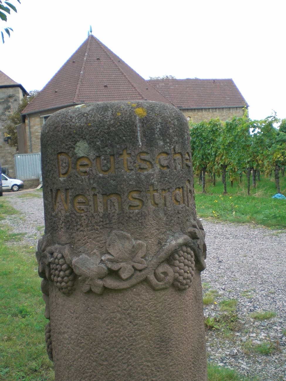 Sandsteinpoller mit Traubengehänge – die alte Markierung der Deutschen Weinstraße.